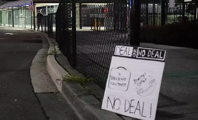 A sign sits just outside the property line for Boeing's Renton factory as a security guard stands behind a fence as Boeing workers picket after union members voted overwhelmingly to reject a contract offer and go on strike Friday, Sept. 13, 2024, in Renton, Wash. (AP Photo/Lindsey Wasson)