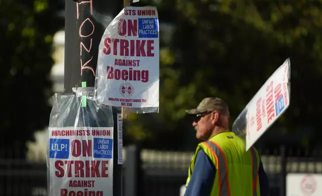 Signs are taped to a light pole as Boeing workers strike Tuesday, Sept. 24, 2024, outside the company's factory in Renton, Wash. (AP Photo/Lindsey Wasson)