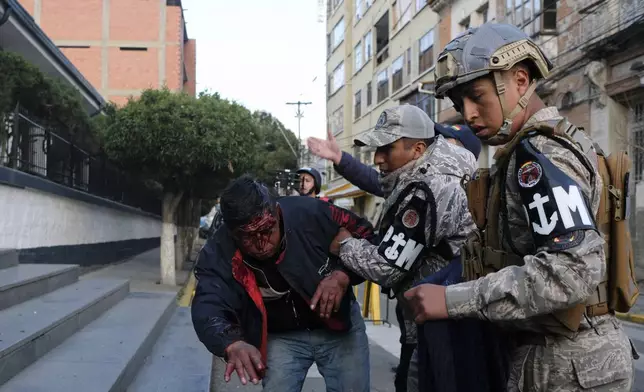 Police tend to a supporter of President Luis Arce who was injured during clashes with sympathizers of former President Evo Morales in La Paz, Bolivia, Monday, Sept. 23, 2024. (AP Photo/Carlos Sanchez)