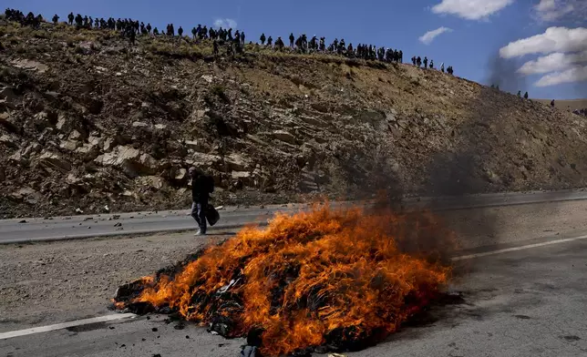 An effigy of former President Evo Morales is engulfed in flames on the road between Caracollo and La Paz, the route Morales' supporters are using to march to the capital against the government of President Luis Arce, in an escalation of a political dispute between the two politicians, Tuesday, Sept. 17, 2024. (AP Photo/Juan Karita)