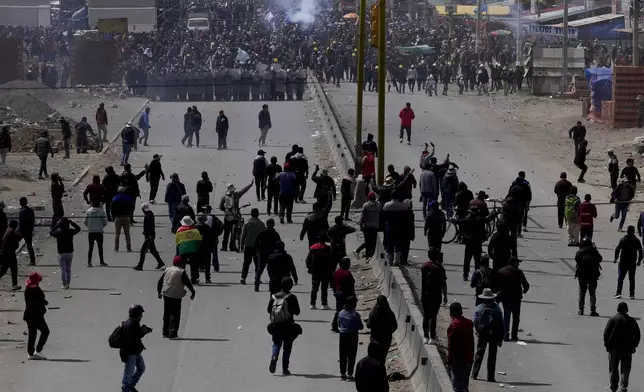 Supporters of former President Evo Morales, below, advance toward supporters of current president Luis Arce in El Alto, Bolivia, Sunday, Sept. 22, 2024. (AP Photo/Juan Karita)