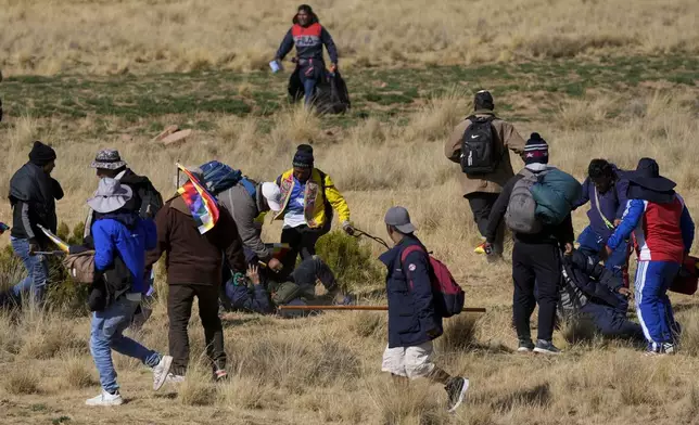 Supporters of former President Evo Morales kick a government supporter whose group confronted them in Vila Vila, Bolivia, during their march to the capital, Tuesday, Sept. 17, 2024. Morales and his supporters are marching to the capital to protest the government of President Luis Arce in an escalation of a political dispute between the two politicians. (AP Photo/Juan Karita)