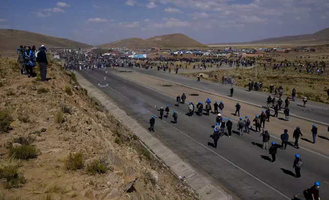 Supporters of former President Evo Morales, top, who are marching to the capital to protest the government of current President Luis Arce, are confronted by Arce supporters, below, in Vila Vila, Bolivia, Tuesday, Sept. 17, 2024. (AP Photo/Juan Karita)