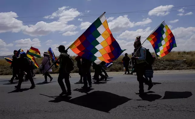 Demonstrators carrying wiphala flags march to the capital from Caracollo, Oruro, Bolivia, led by former President Evo Morales as part of a political dispute with current President Luis Arce and to protest his handling of the economy, Tuesday, Sept. 17, 2024. (AP Photo/Juan Karita)