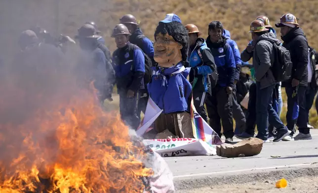 An effigy of former President Evo Morales burns on a road in Vila Vila, Bolivia, to block Morales supporters who are marching to the capital to protest the government of current President Luis Arce in an escalation of a political dispute between the two politicians, Tuesday, Sept. 17, 2024. (AP Photo/Juan Karita)