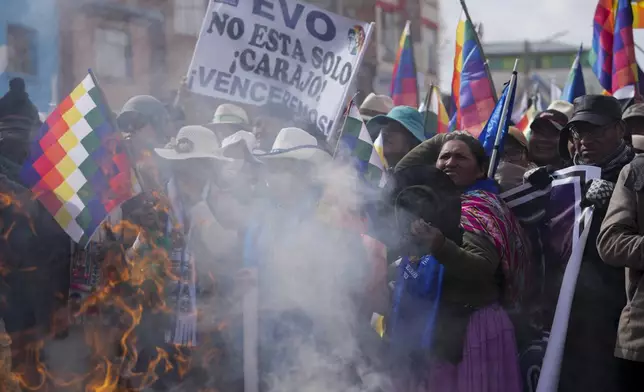 Demonstrators give an offering to Mother Earth before marching to the capital, led by former President Evo Morales, as part of a political dispute with current President Luis Arce and to protest his handling of the economy in Caracollo, Oruro, Bolivia, Tuesday, Sept. 17, 2024. (AP Photo/Juan Karita)