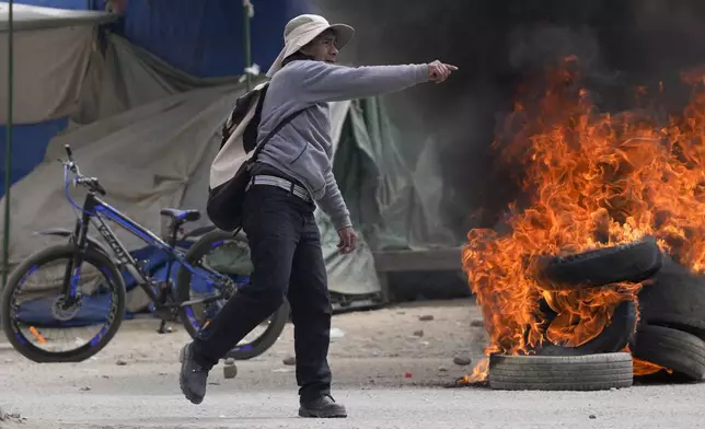 A supporter of former President Evo Morales, protesting the government of current President Luis Arce, clashes with Arce supporters in El Alto, Bolivia, Sunday, Sept. 22, 2024. (AP Photo/Juan Karita)