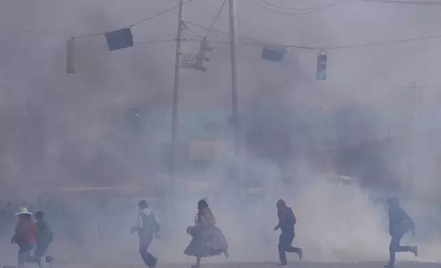 People run through tear gas thrown by police during clashes between supporters of former President Evo Morales and current President Luis Arce in El Alto, Bolivia, Sunday, Sept. 22, 2024. (AP Photo/Juan Karita)