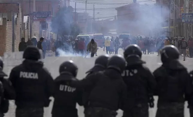 Police stand in front of supporters of former President Evo Morales in El Alto, Bolivia, Sunday, Sept. 22, 2024. (AP Photo/Juan Karita)