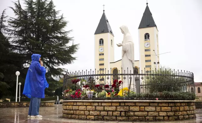 A pilgrim says their prayer next to the statue of the Virgin Mary in Medjugorje, Bosnia, Thursday, Sept. 19, 2024. (AP Photo/Armin Durgut)