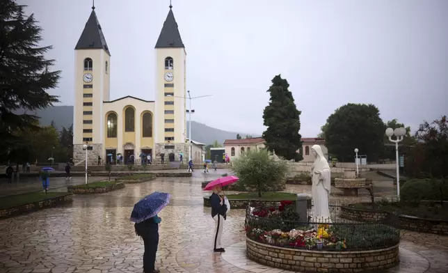 Pilgrims say their prayers next to the statue of the Virgin Mary in Medjugorje, Bosnia, Thursday, Sept. 19, 2024. (AP Photo/Armin Durgut)