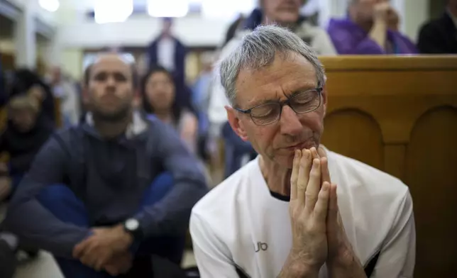 Pilgrims say their prayers inside the St. James Church in Medjugorje, Bosnia, Thursday, Sept. 19, 2024. (AP Photo/Armin Durgut)