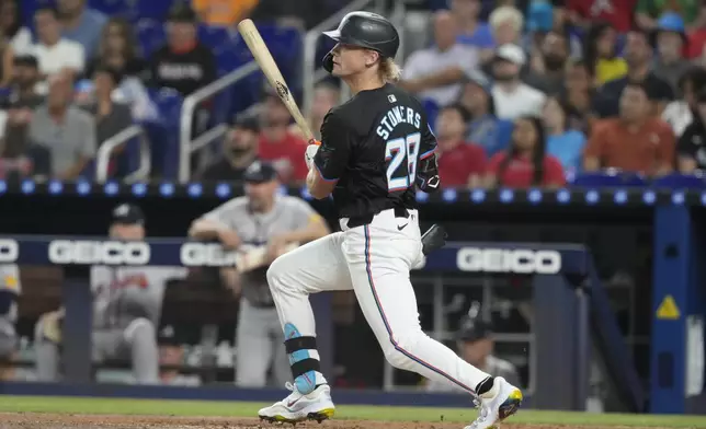 Miami Marlins' Kyle Stowers (28) hits a single during the first inning of a baseball game against the Atlanta Braves, Friday, Sept. 20, 2024, in Miami. (AP Photo/Marta Lavandier)