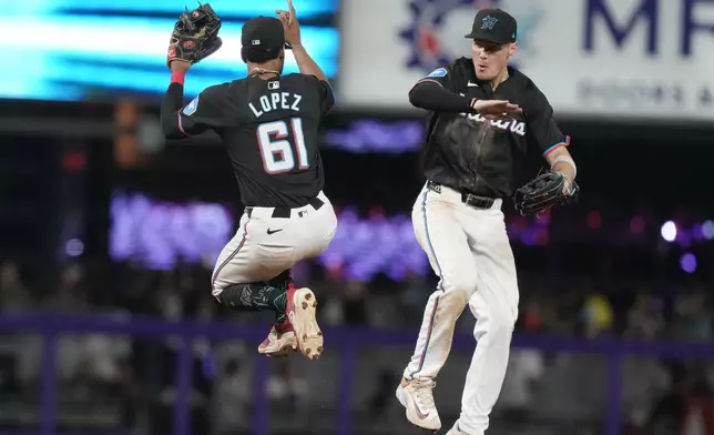 Miami Marlins second baseman Otto Lopez (61) and center fielder Kyle Stowers celebrate at the end of a baseball game against the Atlanta Braves, Friday, Sept. 20, 2024, in Miami. (AP Photo/Marta Lavandier)