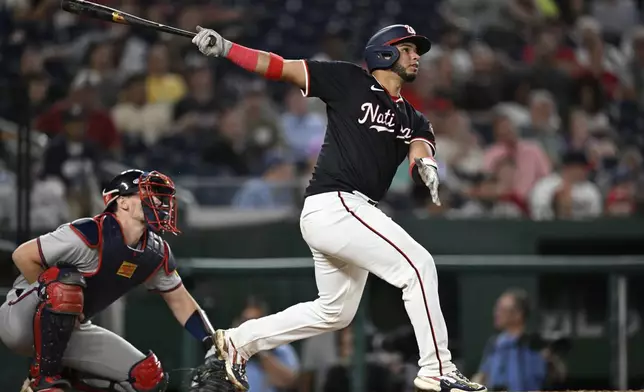 Atlanta Braves catcher Sean Murphy, left, watches the flight of Washington Nationals' Keibert Ruiz's RBI single to right field during the eighth inning of a baseball game, Wednesday, Sept. 11, 2024, in Washington. (AP Photo/John McDonnell)