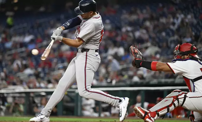 Atlanta Braves' Matt Olson, left, hits a RBI double in front of Washington Nationals catcher Keibert Ruiz during the third inning of a baseball game, Tuesday, Sept. 10, 2024, in Washington. (AP Photo/John McDonnell)