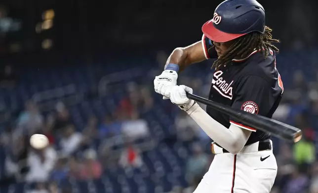 Washington Nationals' James Wood hits an infield single to drive in a run during the third inning of a baseball game against the Atlanta Braves, Wednesday, Sept. 11, 2024, in Washington. (AP Photo/John McDonnell)