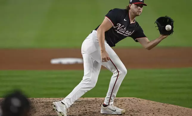 Washington Nationals starting pitcher Jake Irvin fields a louder by Atlanta Braves' Gio Urshela for the second out of the sixth inning of a baseball game, Wednesday, Sept. 11, 2024, in Washington. (AP Photo/John McDonnell)