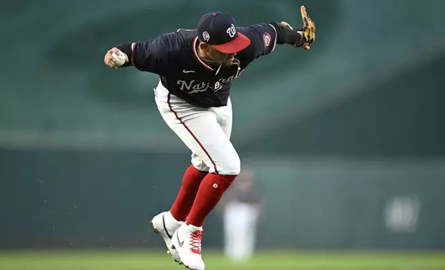 Washington Nationals third baseman Ildemaro Vargas fields a grounder and throws out Atlanta Braves' Orlando Arcia during the second inning of a baseball game, Wednesday, Sept. 11, 2024, in Washington. (AP Photo/John McDonnell)