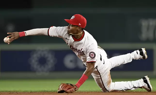 Washington Nationals second baseman Darren Baker tosses the ball to second base to create a double play to end the ninth inning of a baseball game against the Atlanta Braves, Tuesday, Sept. 10, 2024, in Washington. (AP Photo/John McDonnell)