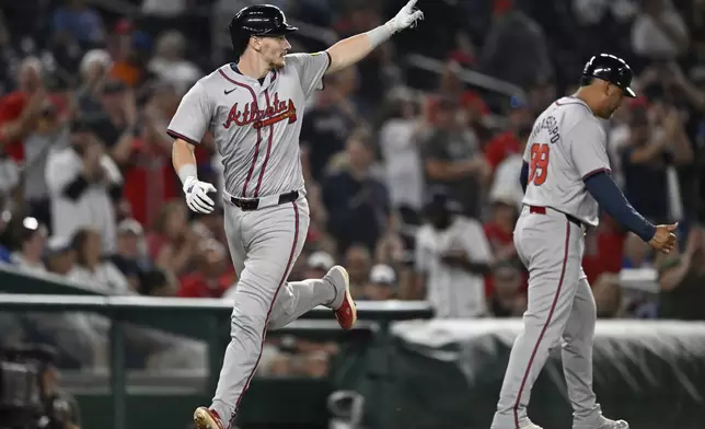 Atlanta Braves' Sean Murphy runs home past Braves third base coach Matt Tuiasosopo after hitting two-run home run during the sixth inning of a baseball game against the Washington Nationals, Tuesday, Sept. 10, 2024, in Washington. (AP Photo/John McDonnell)