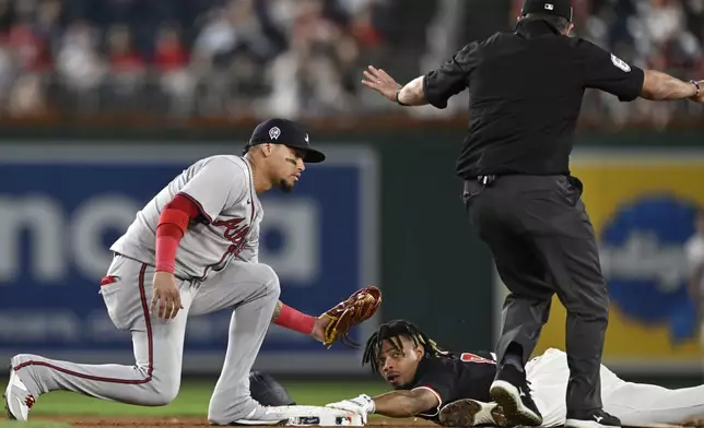 Atlanta Braves shortstop Orlando Arcia, left, is late with the tag as Washington Nationals' Jose Tena steals second base during the eighth inning of a baseball game, Wednesday, Sept. 11, 2024, in Washington. (AP Photo/John McDonnell)