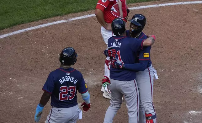 Atlanta Braves' Jorge Soler, right, embraces teammate Orlando Arcia, center, after hitting a 3-run home run during the sixth inning of a baseball game against the Cincinnati Reds, Thursday, Sept. 19, 2024, in Cincinnati. (AP Photo/Joshua A. Bickel)