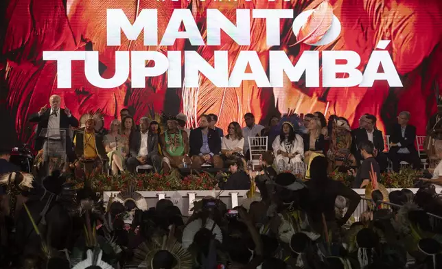 Brazil's President Luiz Inacio Lula da Silva, left, speaks during a ceremony celebrating the return of the Indigenous Tupinamba people's sacred cloak to Brazil, in Rio de Janeiro, Thursday, Sept. 12, 2024. The garment, made from bird feathers and plant fibers, was repatriated to Brazil after having spent more than 300 years in the National Museum of Denmark. (AP Photo/Bruna Prado)