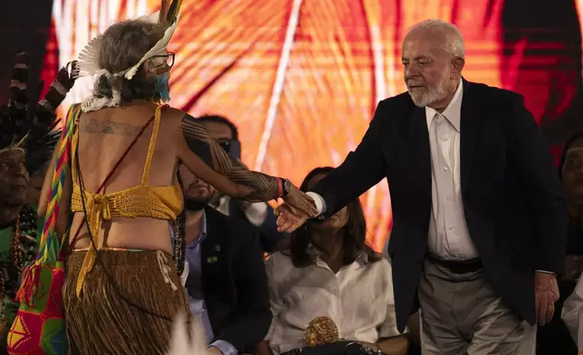 Brazil's President Luiz Inacio Lula da Silva, right, greets Indigenous leader Yakuy Tupinamba during a ceremony celebrating the return of the Indigenous Tupinamba people's sacred cloak to Brazil, in Rio de Janeiro, Thursday, Sept. 12, 2024. The garment, made from bird feathers and plant fibers, was repatriated to Brazil after having spent more than 300 years in the National Museum of Denmark. (AP Photo/Bruna Prado)