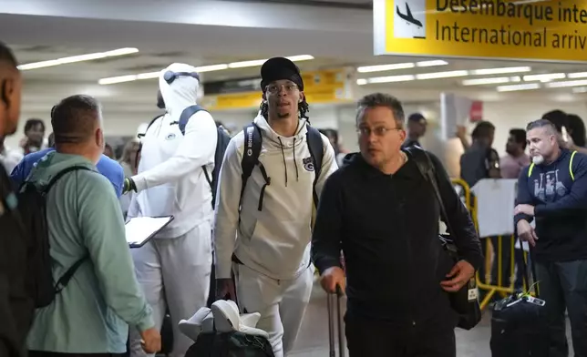 Green Bay Packers' Christian Watson, center, arrives at Sao Paulo International airport ahead of a game against the Philadelphia Eagles, in Guarulhos, great Sao Paulo area, Wednesday, Sept. 4, 2024. (AP Photo/Andre Penner)