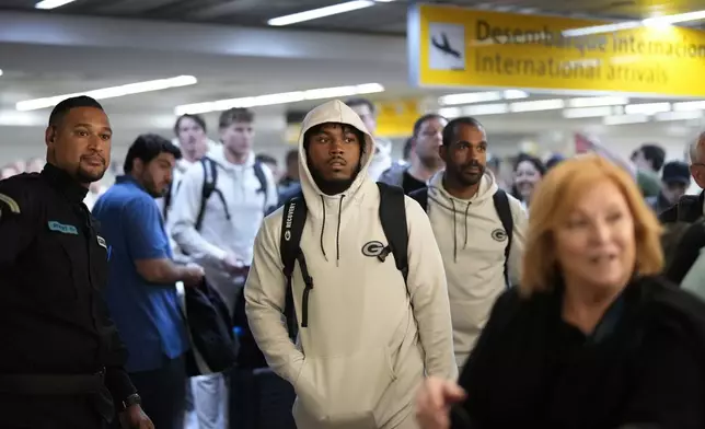 The Green Bay Packers' Josh Jacobs, center, and teammates arrive at Sao Paulo International airport ahead of a game against the Philadelphia Eagles, in Guarulhos, greater Sao Paulo, Brazil, Wednesday, Sept. 4, 2024. (AP Photo/Andre Penner)