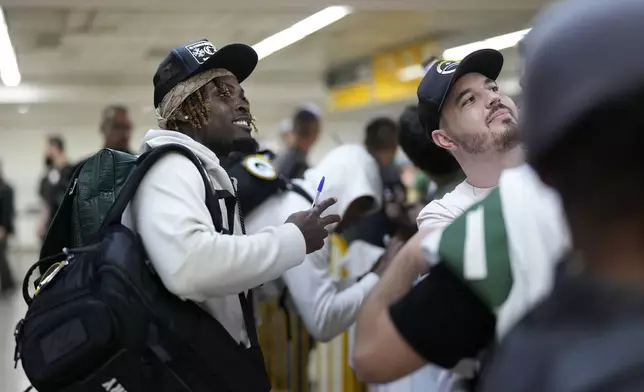 The Green Bay Packers' Jayden Reed poses for a selfie with a fan upon arriving at Sao Paulo International airport ahead of a game against the Philadelphia Eagles, in Guarulhos, greater Sao Paulo, Brazil, Wednesday, Sept. 4, 2024. (AP Photo/Andre Penner)