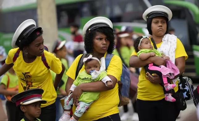 Women holding babies wait for the start of the Defense of Religious Freedom march at Copacabana beach in Rio de Janeiro, Sunday, Sept. 15, 2024. The march seeks to bring attention to religious intolerance in the country. (AP Photo/Silvia Izquierdo)