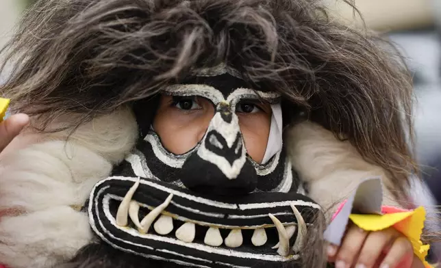 A youth wears a mask during the Defense of Religious Freedom march at Copacabana beach in Rio de Janeiro, Sunday, Sept. 15, 2024. The march seeks to bring attention to religious intolerance in the country. (AP Photo/Silvia Izquierdo)