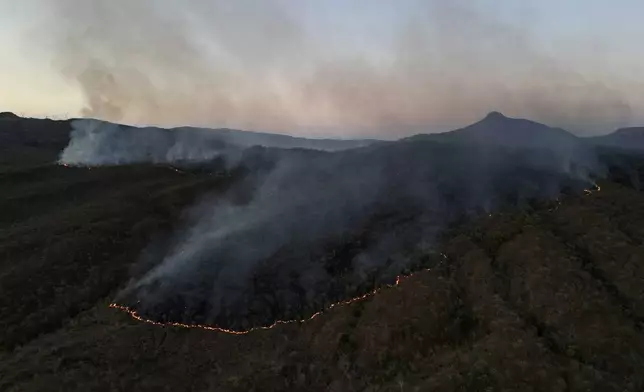 Fires spread through the environmental protection area of Pouso Alto, in Chapada dos Veadeiros National Park, during dry season, in Minas Sul, Goias state, Brazil, Monday, Sept. 9, 2024. (AP Photo/Eraldo Peres)