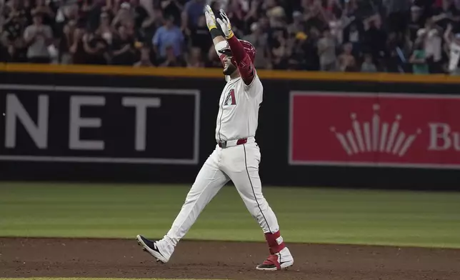 Arizona Diamondbacks' Eugenio Suárez celebrates his walk off RBI single in the bottom of the 10th inning of a baseball game against the Milwaukee Brewers, Sunday, Sept. 15, 2024, in Phoenix. Arizona won 11-10. (AP Photo/Darryl Webb)