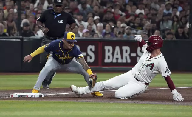 Milwaukee Brewers third base Joey Ortiz, left, tags out Arizona Diamondbacks' Christian Walker trying to advance in the third inning during a baseball game, Friday, Sept. 13, 2024, in Phoenix. (AP Photo/Rick Scuteri)