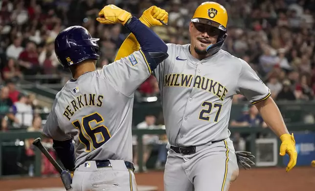 Milwaukee Brewers' Willy Adames, right, celebrates after his second home run against the Arizona Diamondbacks with Blake Perkins (16) during the fourth inning of a baseball game, Saturday, Sept. 14, 2024, in Phoenix. (AP Photo/Darryl Webb)