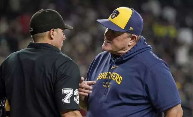 Milwaukee Brewers manager Pat Murphy, right, talks to home plate umpire Tripp Gibson, left, between innings of a baseball game against the Arizona Diamondbacks, Saturday, Sept. 14, 2024, in Phoenix. (AP Photo/Darryl Webb)