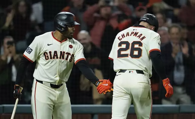 San Francisco Giants' Matt Chapman, right, is congratulated by LaMonte Wade Jr., left, after hitting a solo home run during the fourth inning of a baseball game against the Milwaukee Brewers, Wednesday, Sept. 11, 2024, in San Francisco. (AP Photo/Godofredo A. Vásquez)