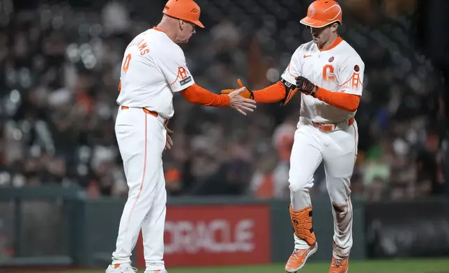 San Francisco Giants' Mike Yastrzemski, right, is congratulated by third base coach Matt Williams (9) as he rounds the bases after hitting a solo home run against the Milwaukee Brewers during the sixth inning of a baseball game, Tuesday, Sept. 10, 2024, in San Francisco. (AP Photo/Tony Avelar)