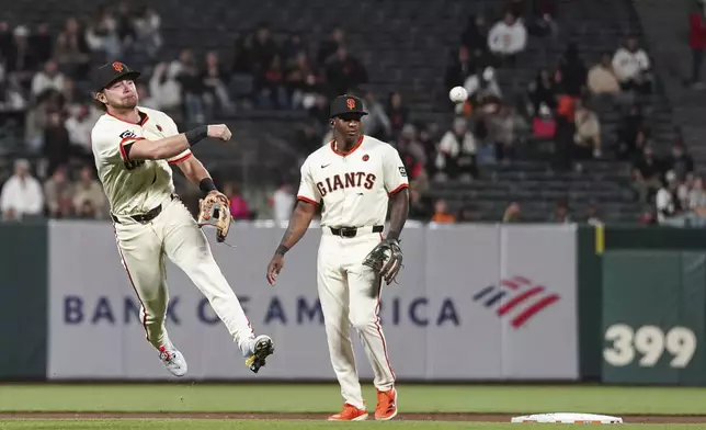 San Francisco Giants shortstop Brett Wisely, left, throws out Milwaukee Brewers' Joey Ortiz at first base during the fifth inning of a baseball game in San Francisco, Thursday, Sept. 12, 2024. (AP Photo/Kavin Mistry)