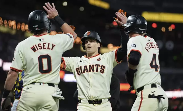 San Francisco Giants' Mike Yastrzemski, center, celebrates with Brett Wisely, left, and Tyler Fitzgerald after hitting a three-run home run during the second inning of a baseball game against the Milwaukee Brewers, Wednesday, Sept. 11, 2024, in San Francisco. (AP Photo/Godofredo A. Vasquez)