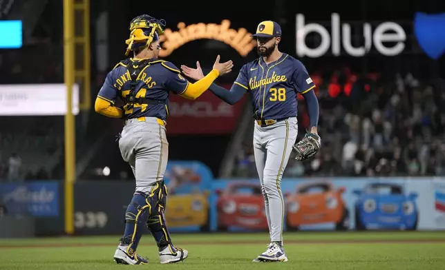 Milwaukee Brewers pitcher Devin Williams (38) is congratulated by catcher William Contreras (24) after a victory against the San Francisco Giants in a baseball game Tuesday, Sept. 10, 2024, in San Francisco. (AP Photo/Tony Avelar)