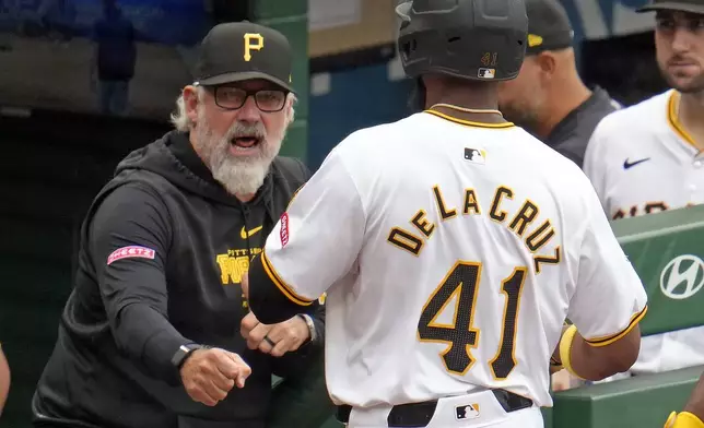 Pittsburgh Pirates manager Derek Shelton, left, welcomes Bryan De La Cruz (41) back to the dugout after hitting a two-run home off Milwaukee Brewers relief pitcher Nick Mears during the seventh inning of a baseball game in Pittsburgh, Thursday, Sept. 26, 2024. (AP Photo/Gene J. Puskar)