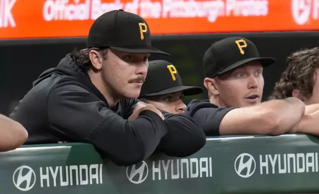 Pittsburgh Pirates pitcher Paul Skenes, left, with fellow pitchers Jared Jones, center, and Mitch Keller, right, watch from the dugout railing during the seventh inning of a baseball game against the Milwaukee Brewers in Pittsburgh, Tuesday, Sept. 24, 2024. (AP Photo/Gene J. Puskar)
