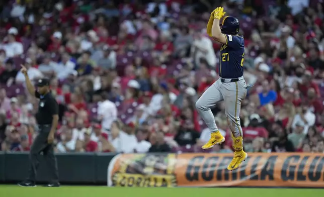 Milwaukee Brewers' Willy Adames leaps as he rounds the bases after hitting a three-run home run during the third inning of a baseball game against the Cincinnati Reds, Saturday, Aug. 31, 2024, in Cincinnati. (AP Photo/Carolyn Kaster)