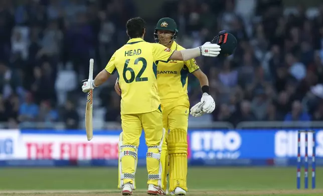 Australia's Travis Head celebrates 100 runs with batting partner Marnus Labuschagne during the first one day international match between England and Australia, at Trent Bridge, Nottingham, England, Thursday Sept. 19, 2024. (Nigel French/PA via AP)