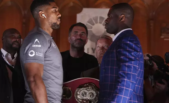 Anthony Joshua (left) and Daniel Dubois face off during a press conference during a press conference at the Guildhall, London, Thursday Sept. 19, 2024. The IBF heavyweight title fight between Anthony Joshua and Daniel Dubois will take place on Saturday 21st September. (Bradley Collyer/PA via AP)