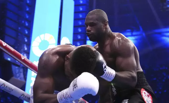 Daniel Dubois, right, knocks down Anthony Joshua in the IBF World Heavyweight bout at Wembley Stadium, in London, Saturday Sept. 21, 2024. (Bradley Collyer/PA via AP)